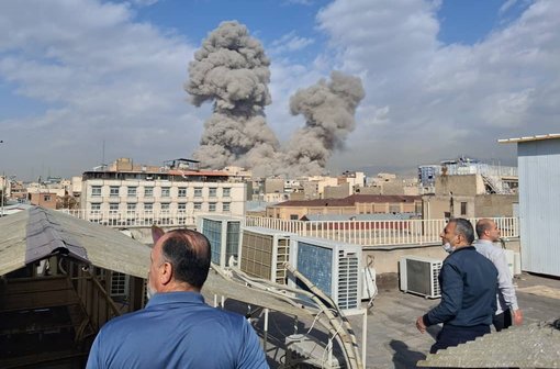 People watch as smoke rises on the skyline after an explosion in Tehran, Iran, Saturday, Feb. 28, 2026.(AP Photo)